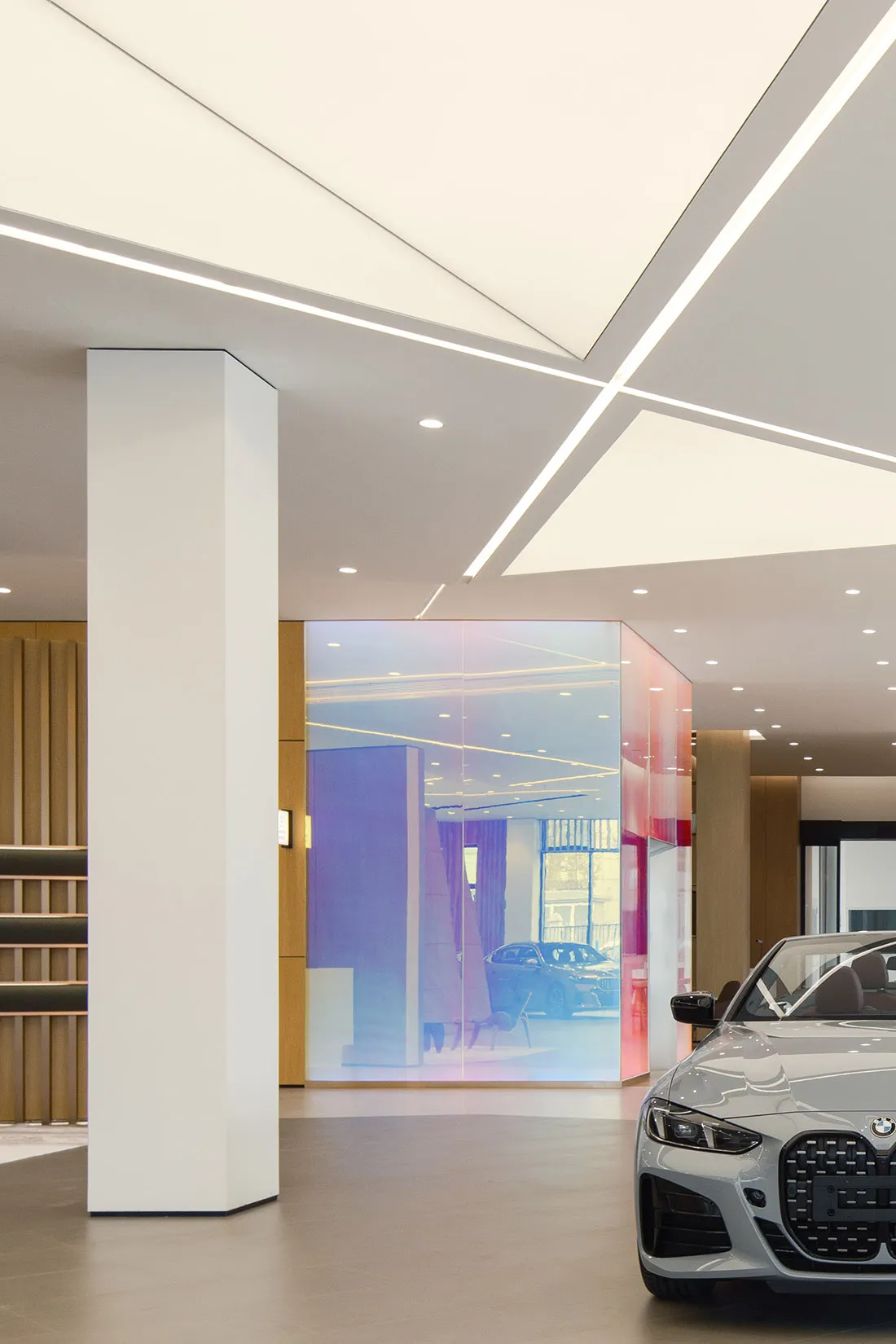 A well-lit, modern car dealership interior with sleek design elements and glass partitions.