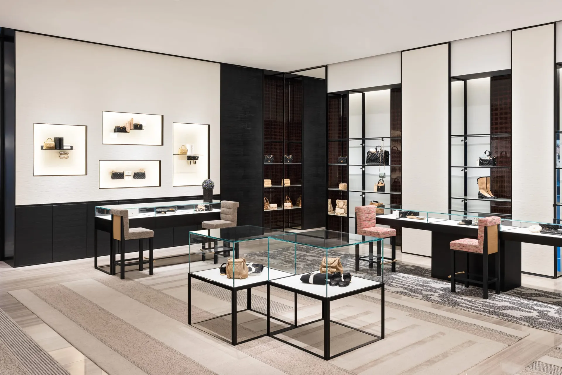 A luxurious retail shop showcasing minimalist design with glass display cases, wood furniture, and metal accents.