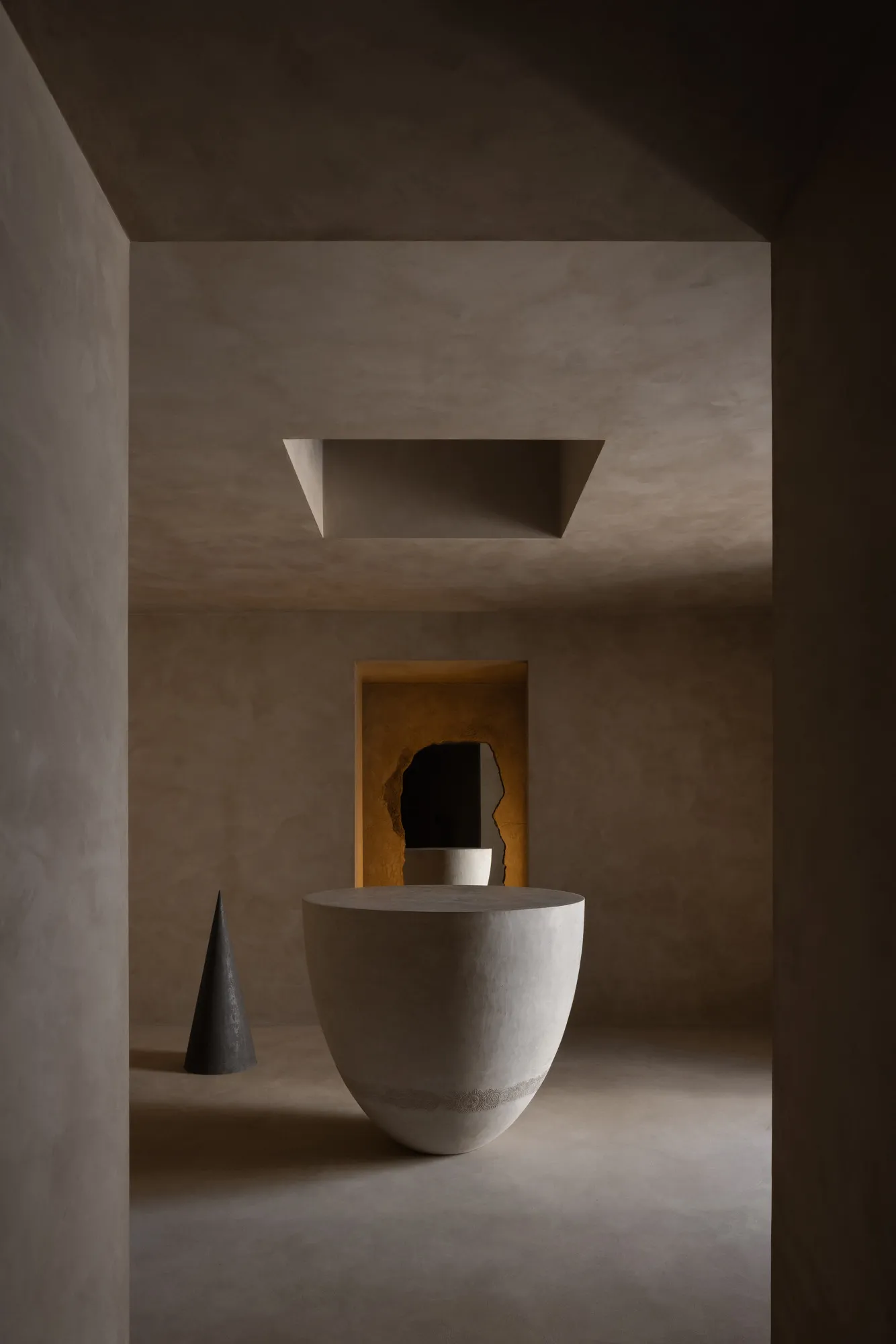 Minimalist interior design featuring a concrete vase and cone-shaped sculpture.