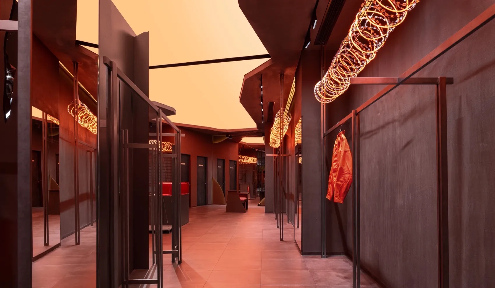 A modern clothing store with metallic textile walls and clothing on racks.
