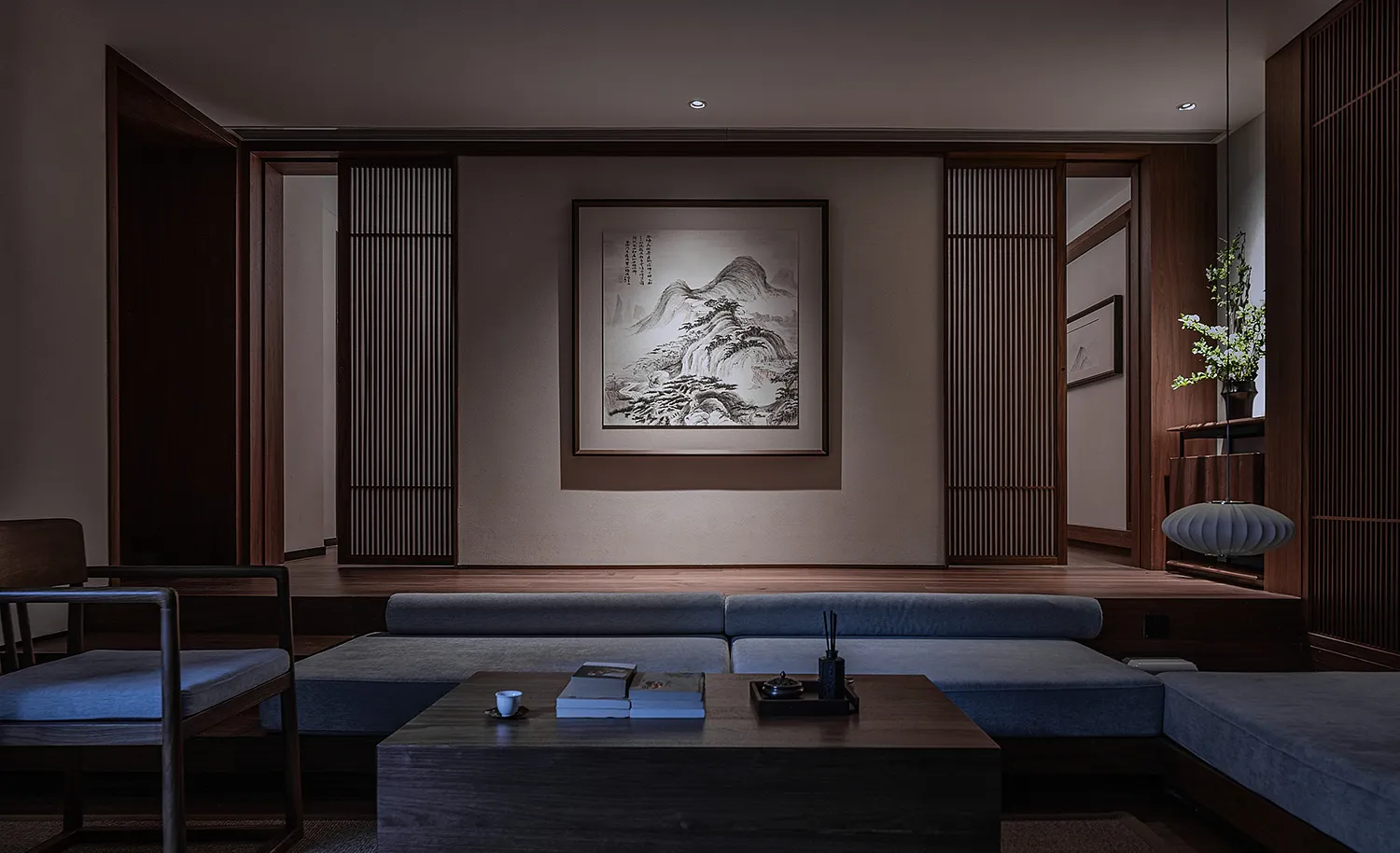 A modern minimalist living room featuring wooden furniture, a black coffee table, a grey sectional sofa, and a framed black a