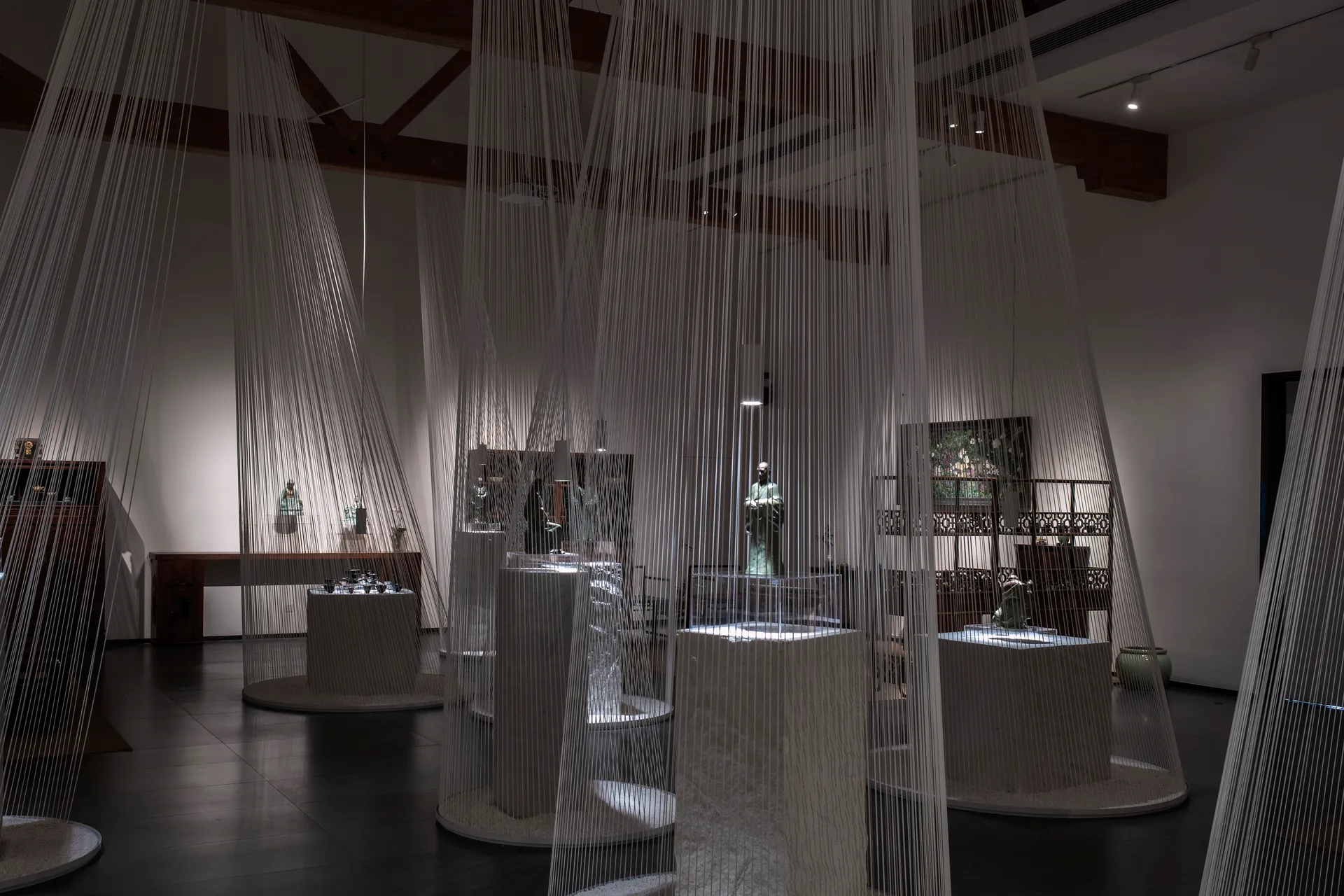 An interior design exhibition featuring a curtain made of thin strings hanging from the ceiling.