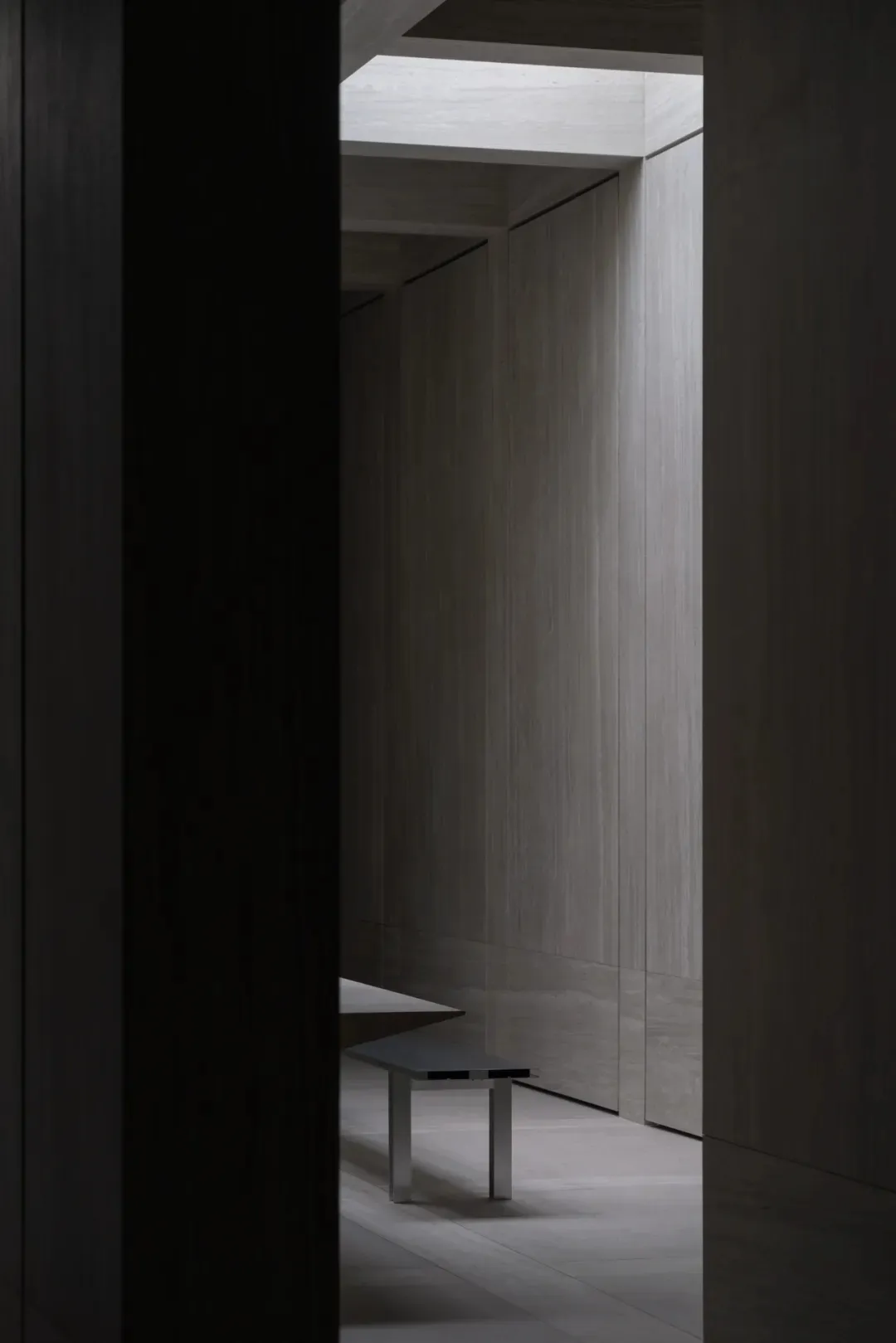 Minimalist interior space with wooden paneling and modern furniture.
