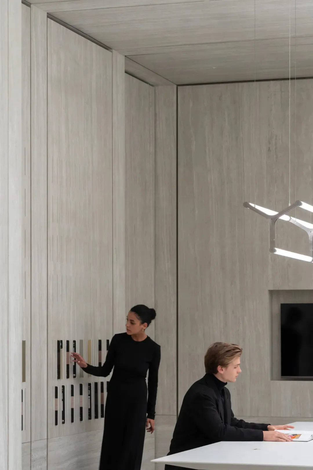 An image depicting a modern office space featuring concrete walls and a paneled office desk.