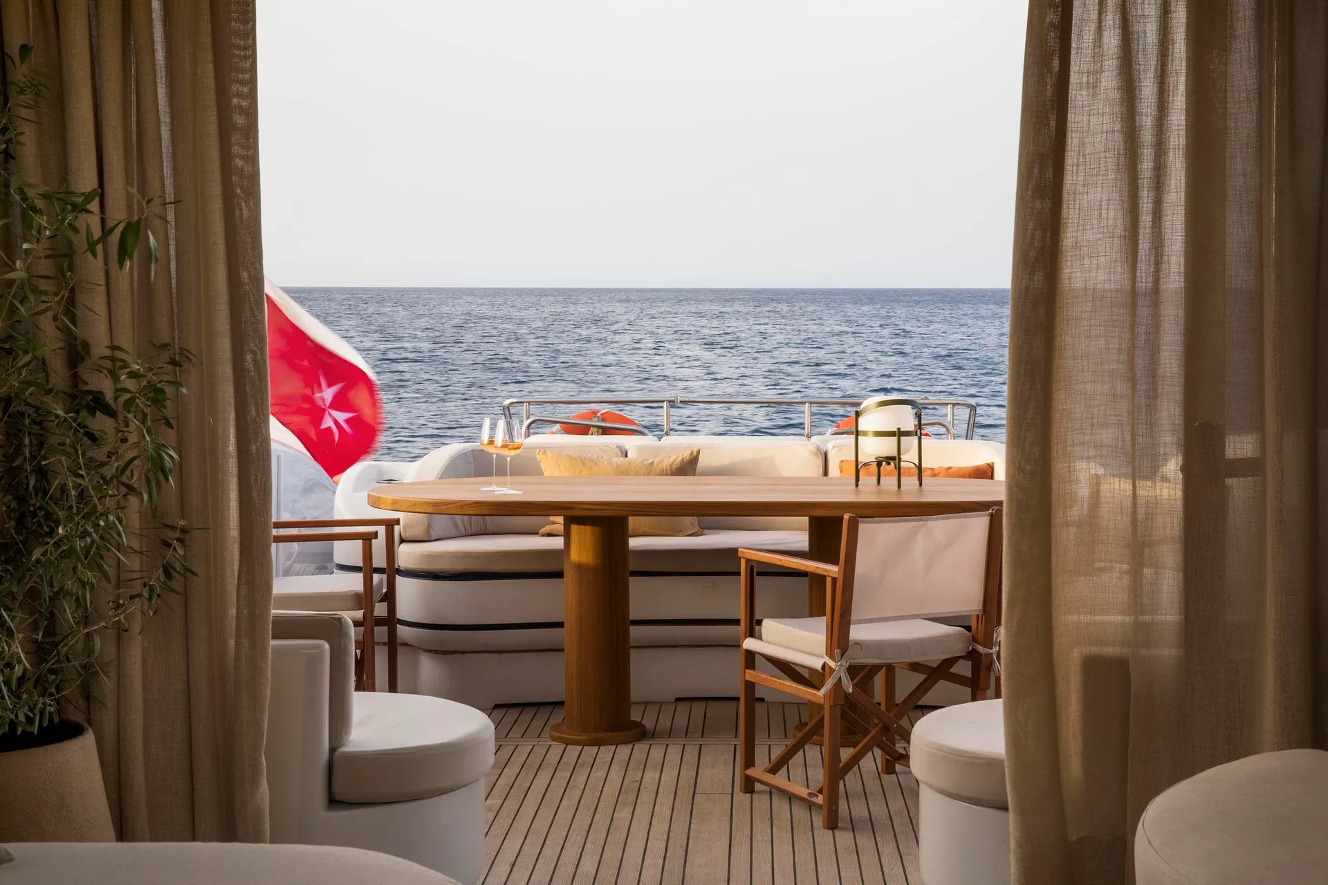 Modern yacht terrace with industrial design elements, featuring wood furniture and leather seating.