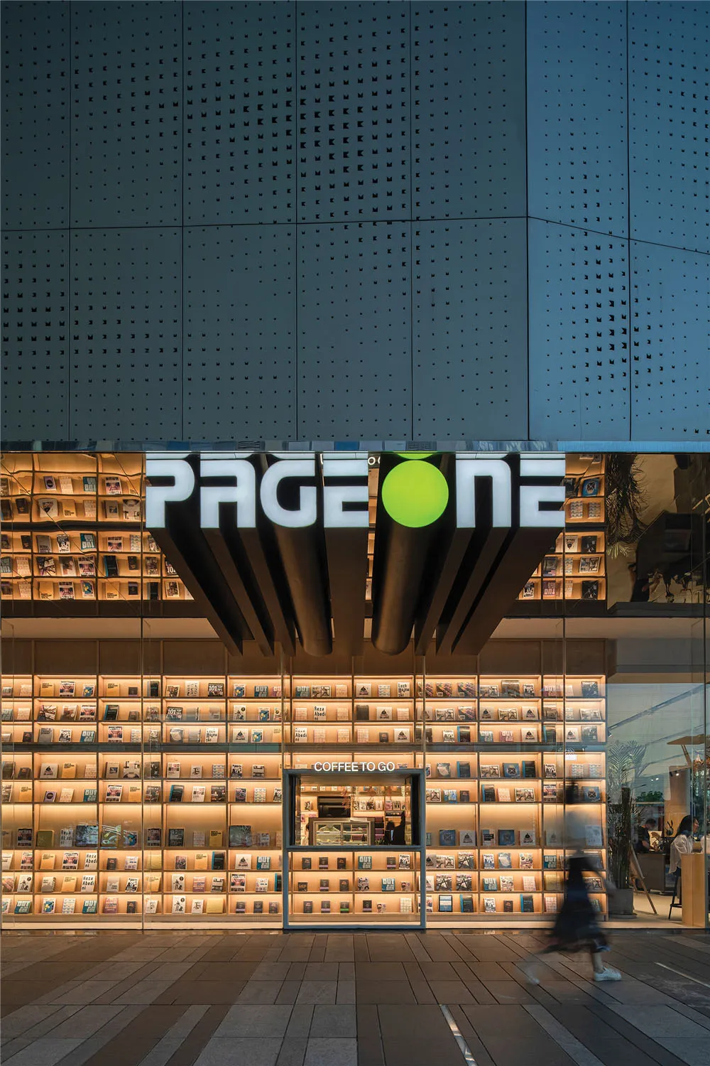 書店外觀，擁有大型發光店面，採用現代設計搭配淺色木質與玻璃元素