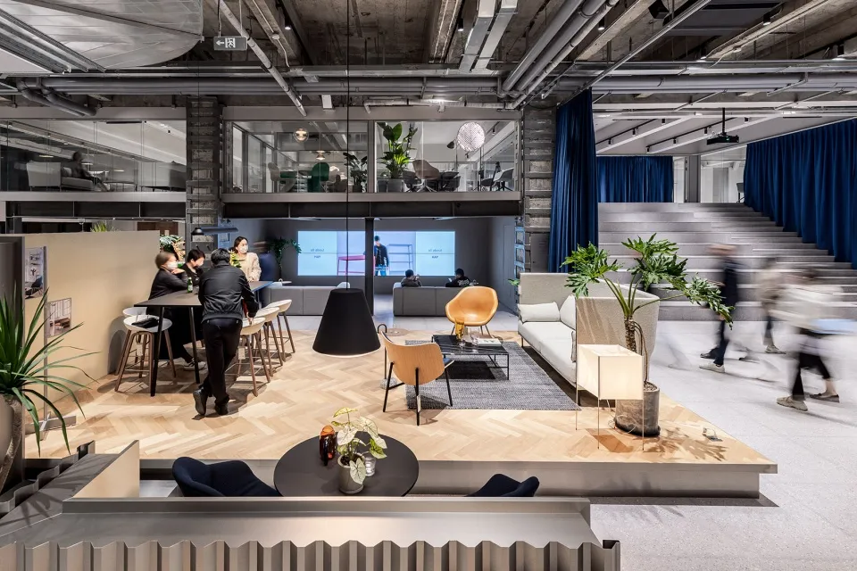 A modern coworking space with a mix of materials and furniture.