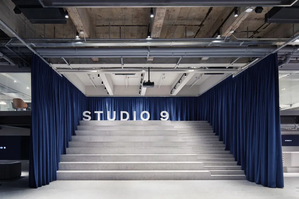 A modern, corporate space featuring granite stairs and blue curtains