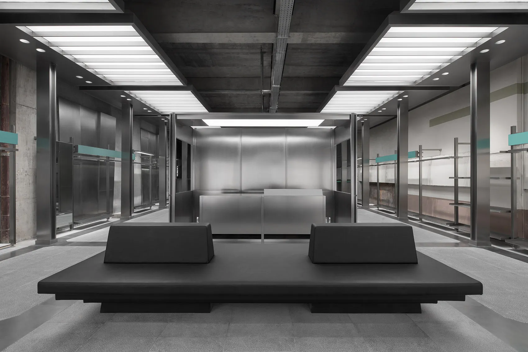 Modern industrial office lobby with metallic surfaces and minimalist design.