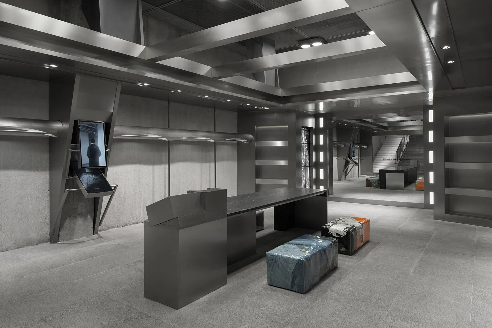 Modern retail space featuring industrial design elements such as metal finishes, concrete walls, and large glass panels.