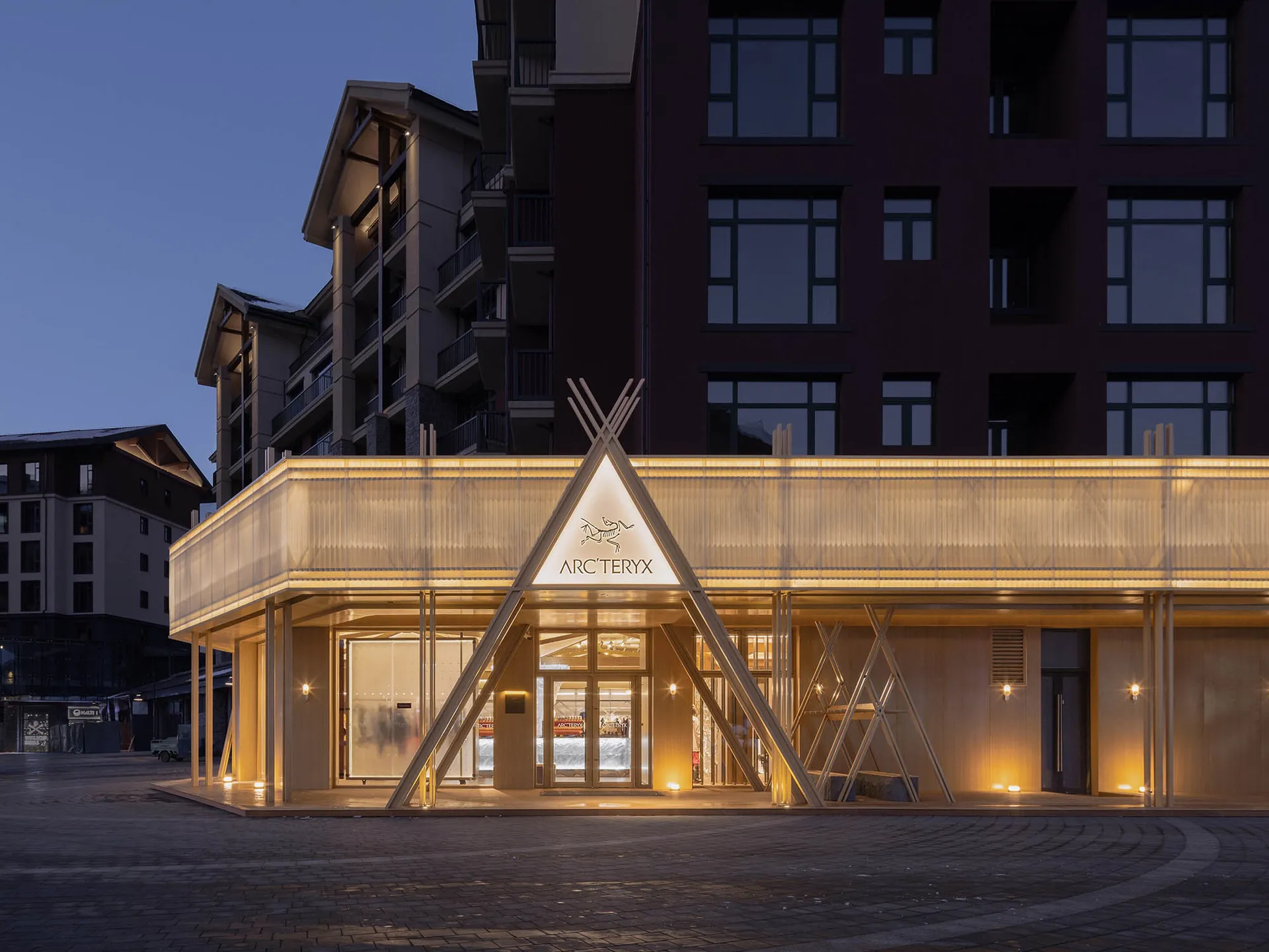 Modern retail storefront with glass walls, wooden accents, and metallic details.