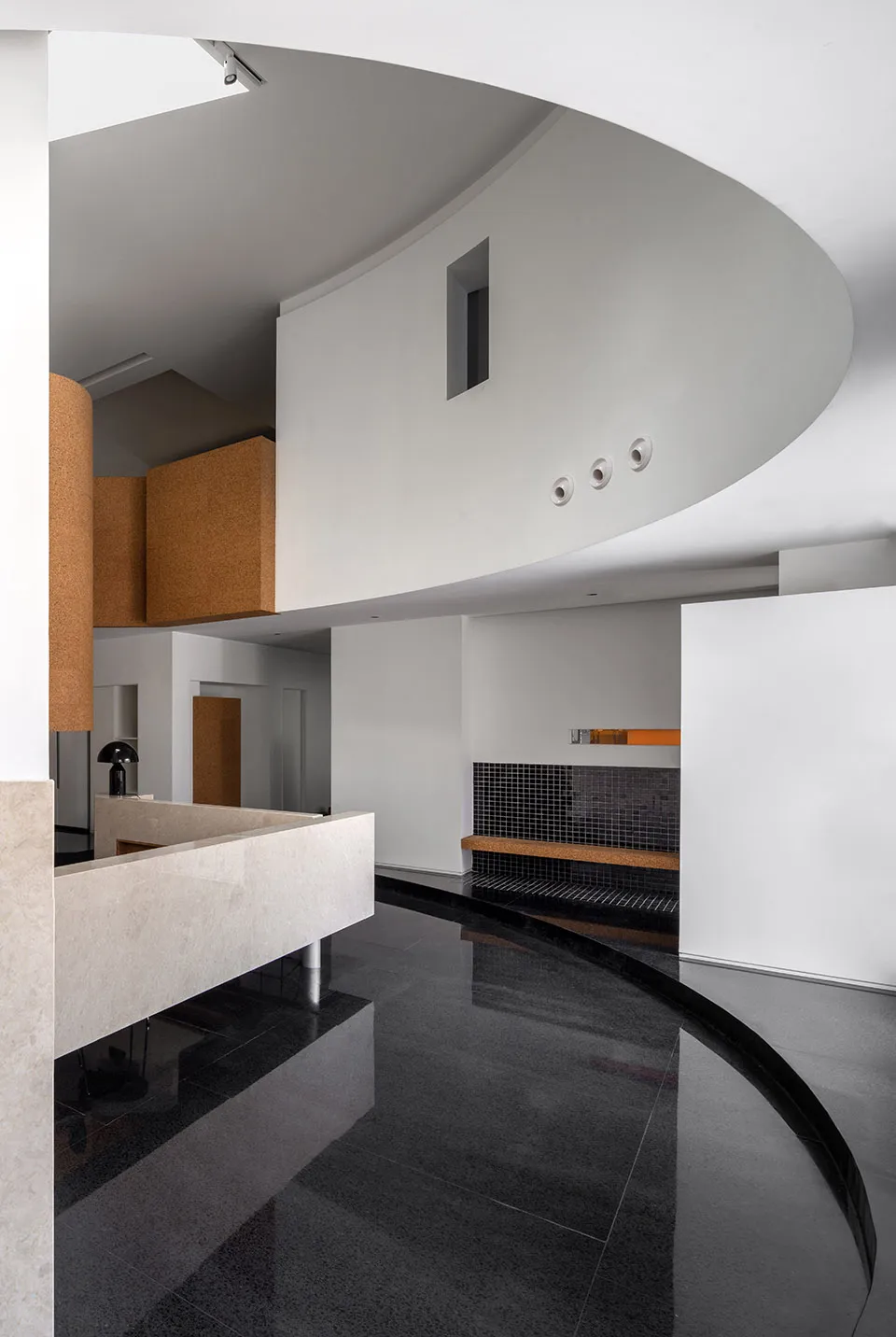 A modern interior design featuring black, concrete flooring and minimalist furniture.
