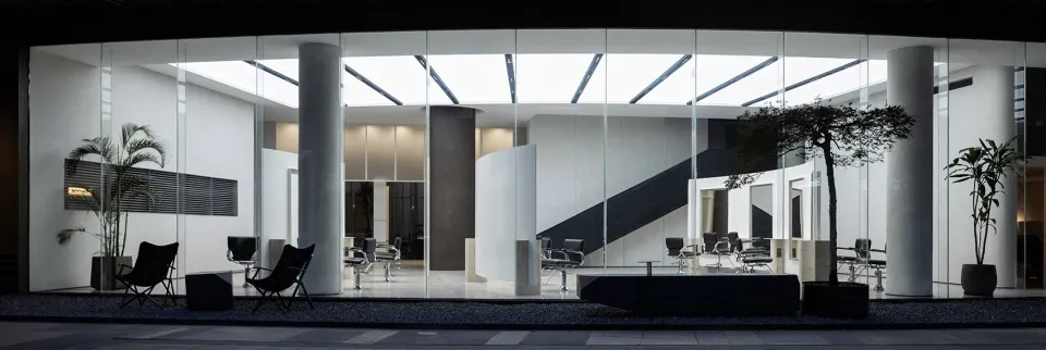 A modern office with a glass wall providing natural light.