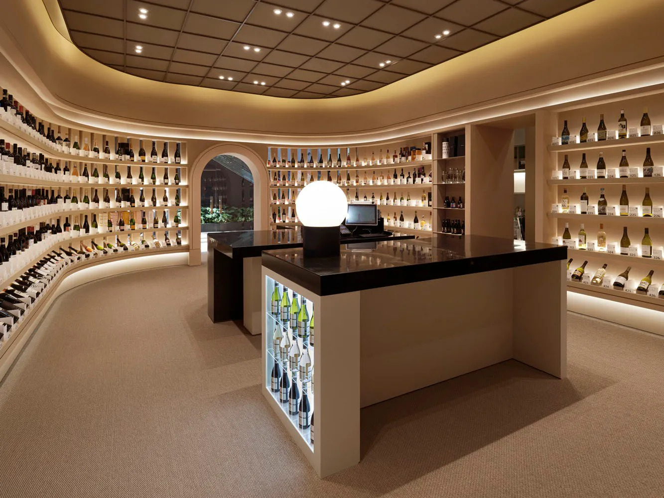 A wine shop with backlit glass shelves and a curved arch.