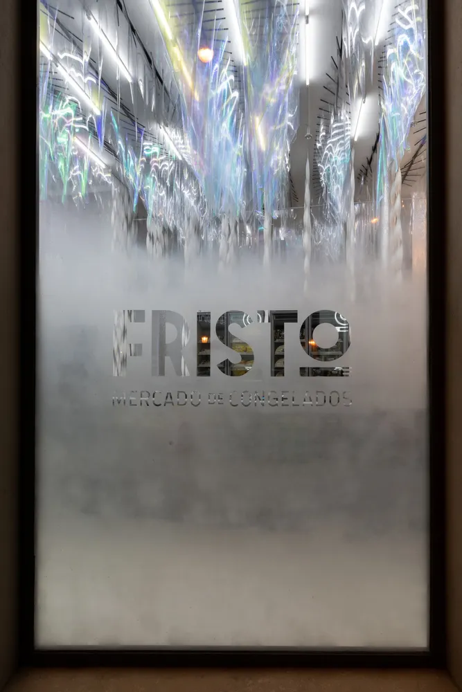 A frosted storefront window with the word 'Fristo' and the words 'Mercado De Congelados' written in frosted glass.