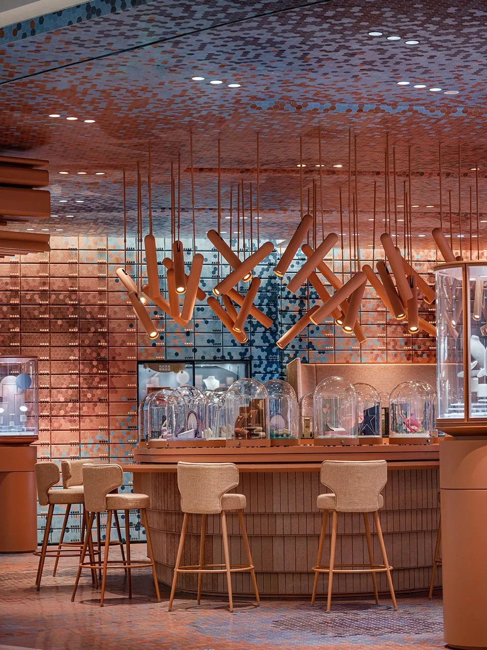 Modern bar interior with wood stools, concrete shelving, and glass dome displays.