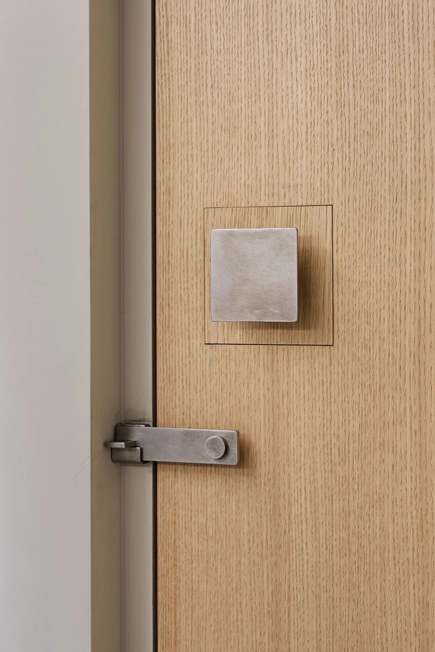 A modern door handle in metal and wood.