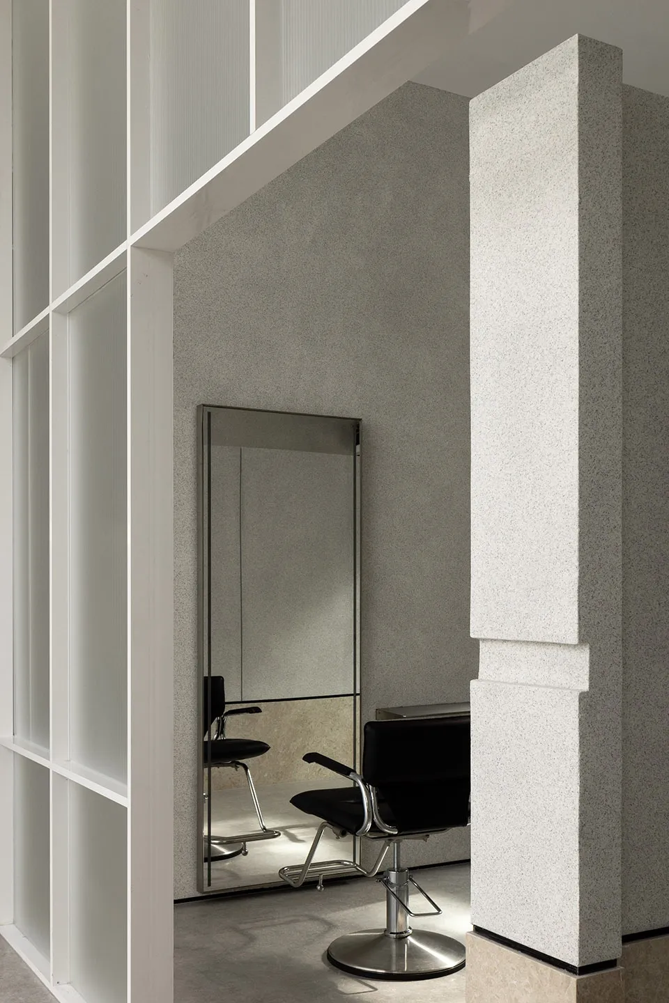 Modern minimalist salon featuring metallic furniture and large mirrors.