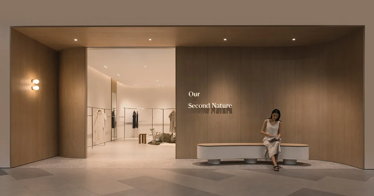 A minimalist retail store with wooden walls, concrete flooring, and well-placed lighting fixtures.