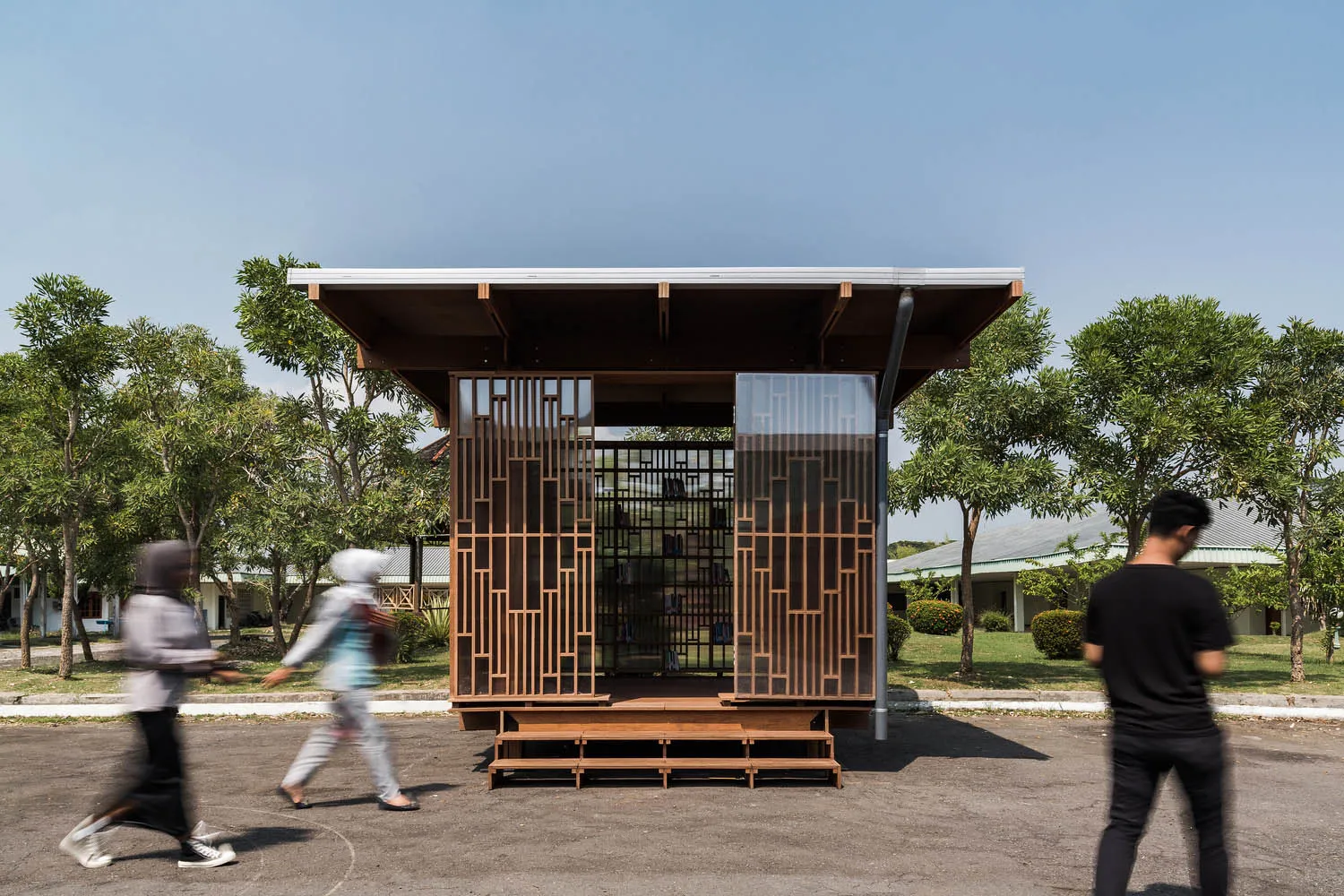 A modern library constructed with wooden materials and featuring a clear glass wall.