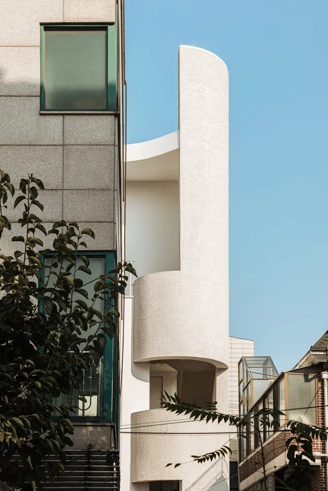 Modern residential building with a curved concrete exterior.