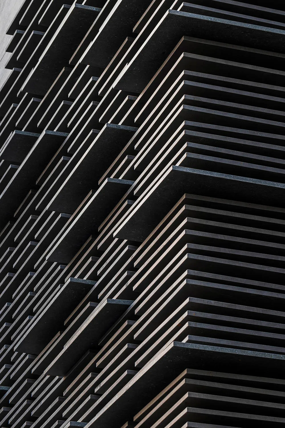 A close-up view of a modern building facade with black metallic panels.