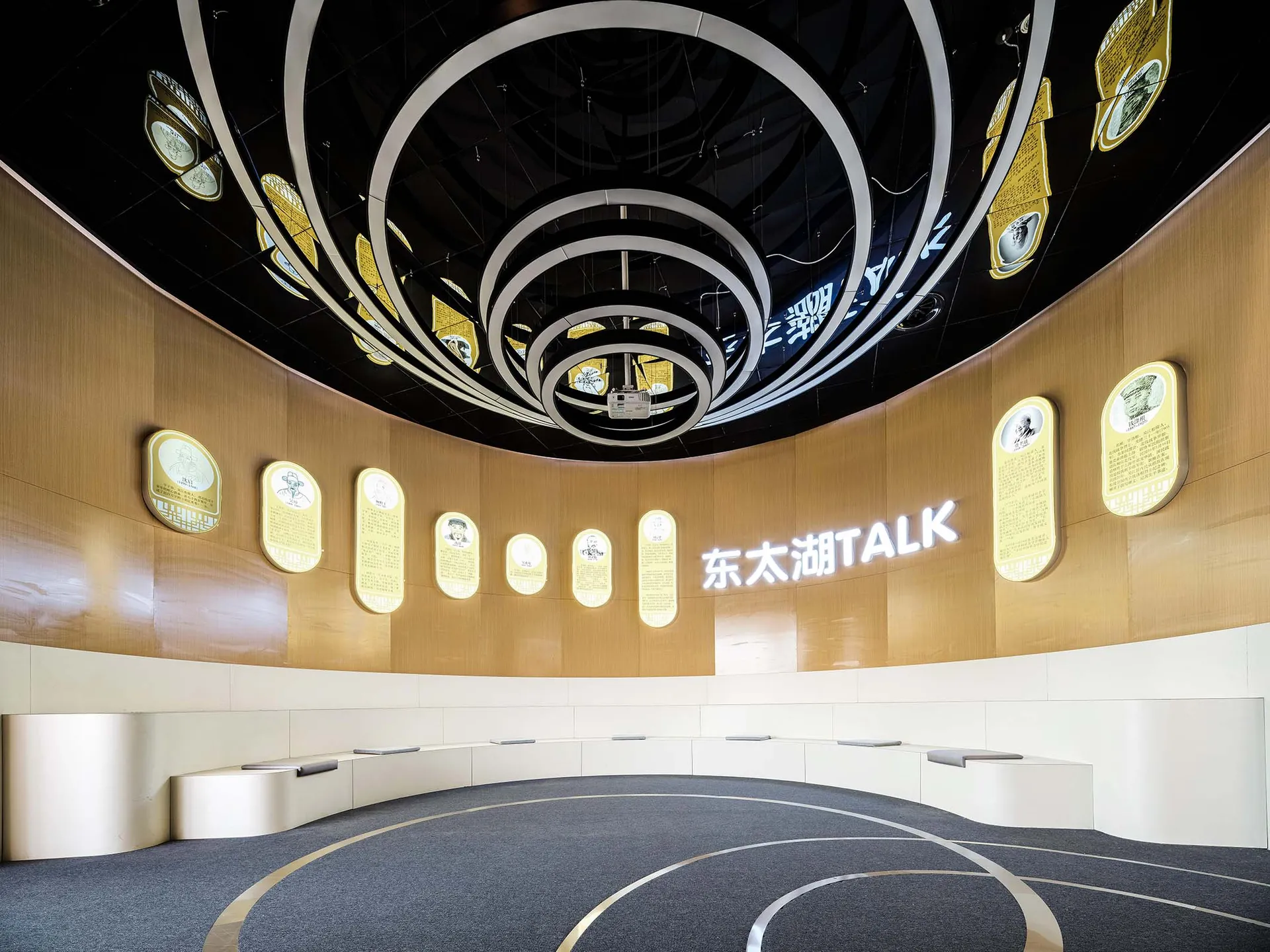 A modern conference room with wooden walls and circular light fixtures hanging from the ceiling.