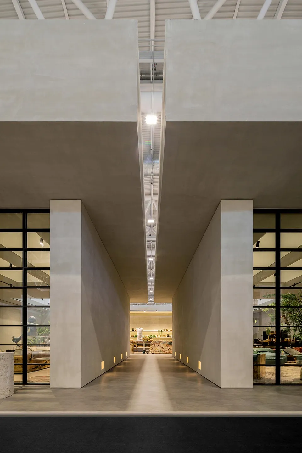 A long, modern industrial lobby with concrete walls and glass elements.