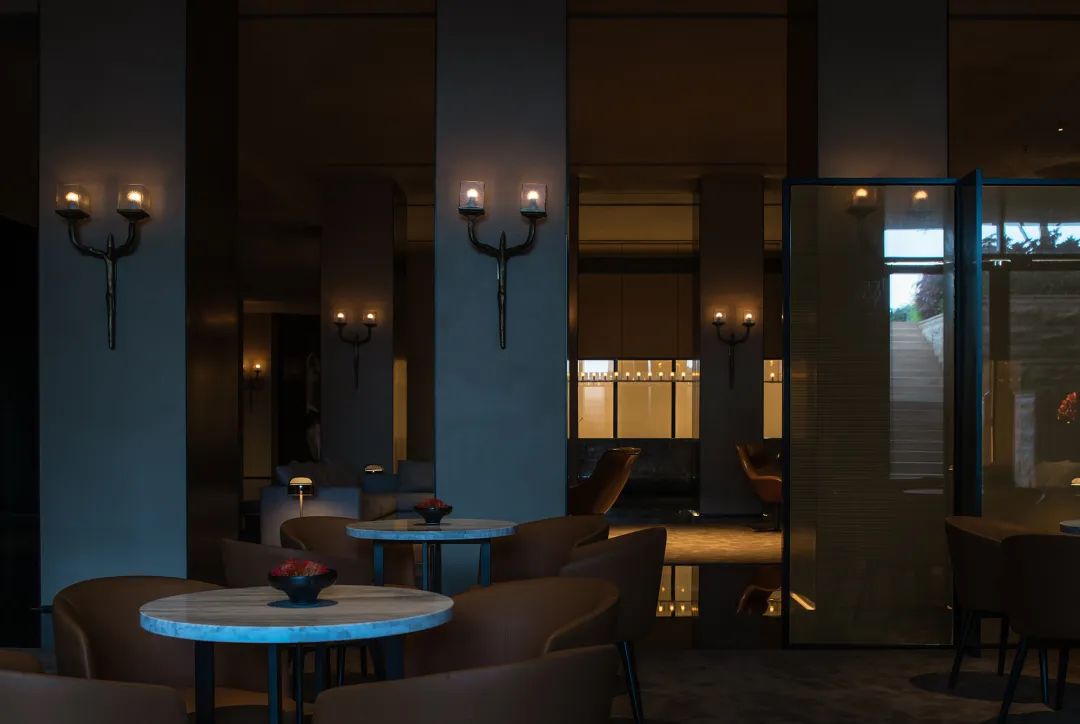 Modern lobby interior with concrete walls and a glass partition.