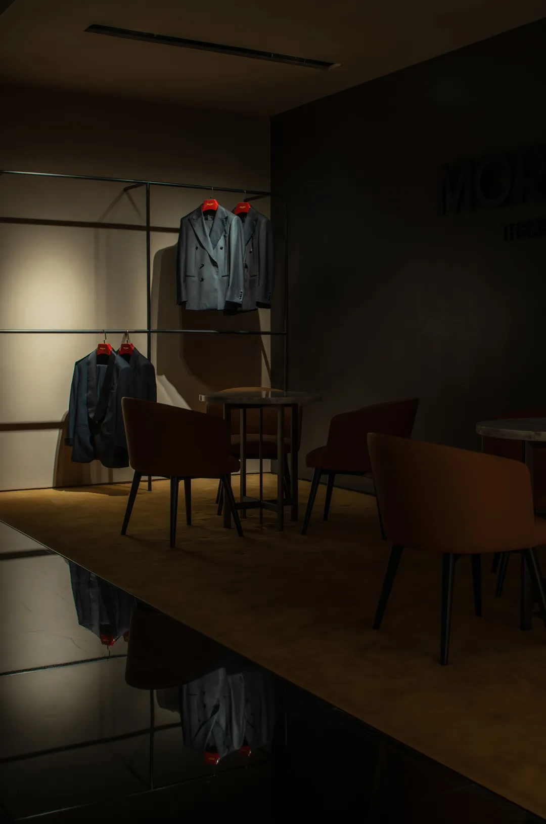 Modern retail storefront with metal structure and blue jackets hanging on a clothes rack