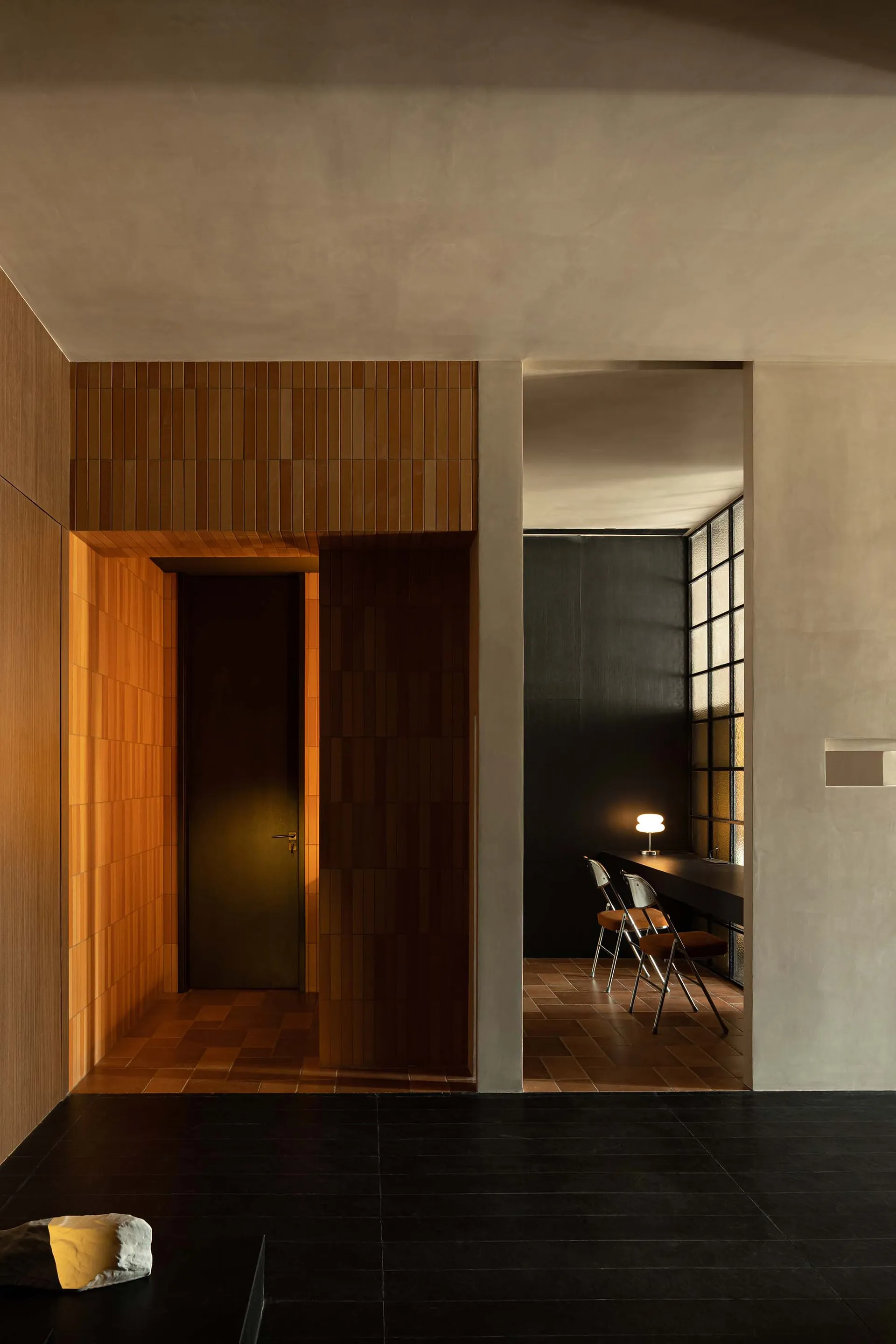 Modern interior corridor with brick walls and folding chairs.