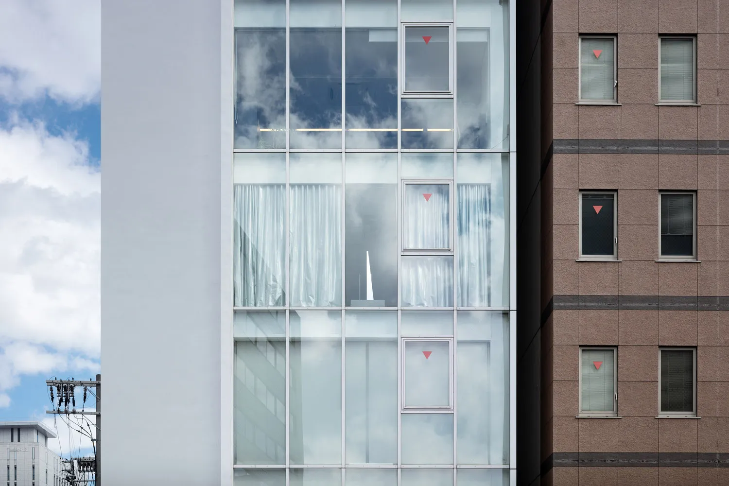 Reflections of a modern office building with a glass facade on a clear day.