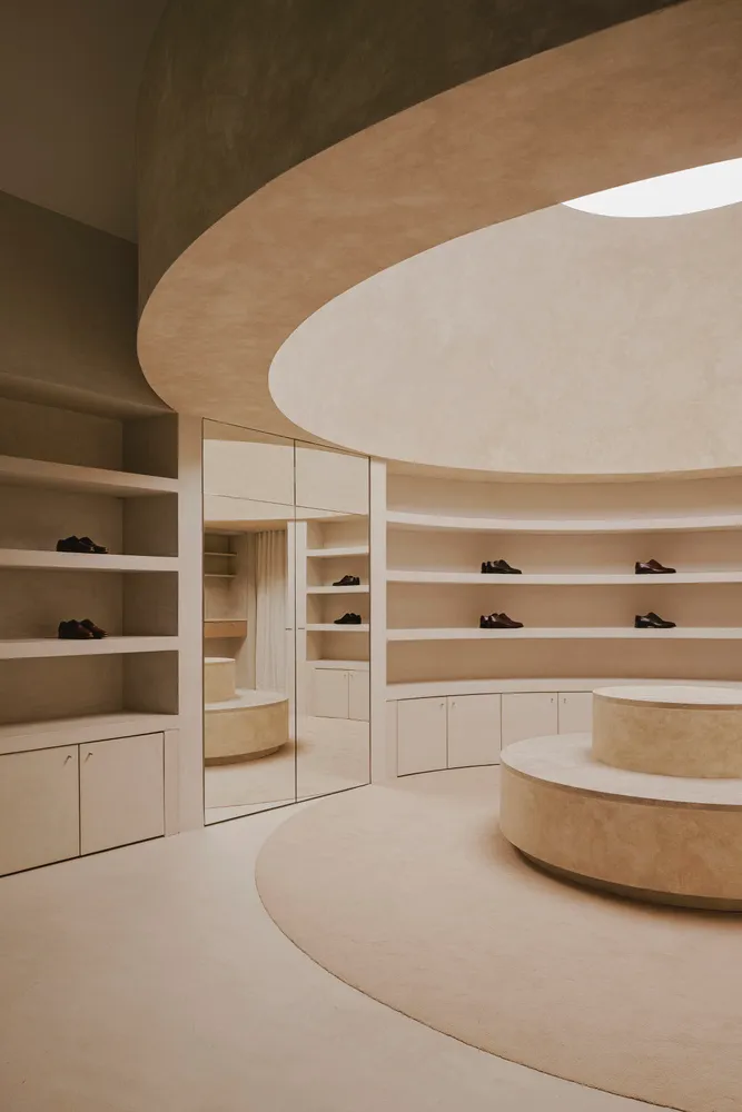 A modern retail space featuring a concrete shoe display shelf.