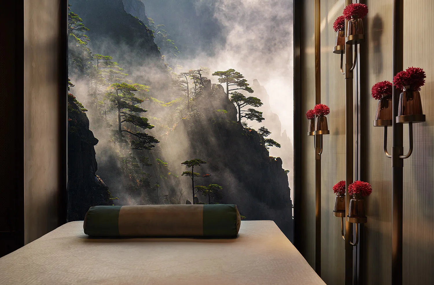 A tranquil spa relaxation room with a view of a misty mountain landscape through a window.