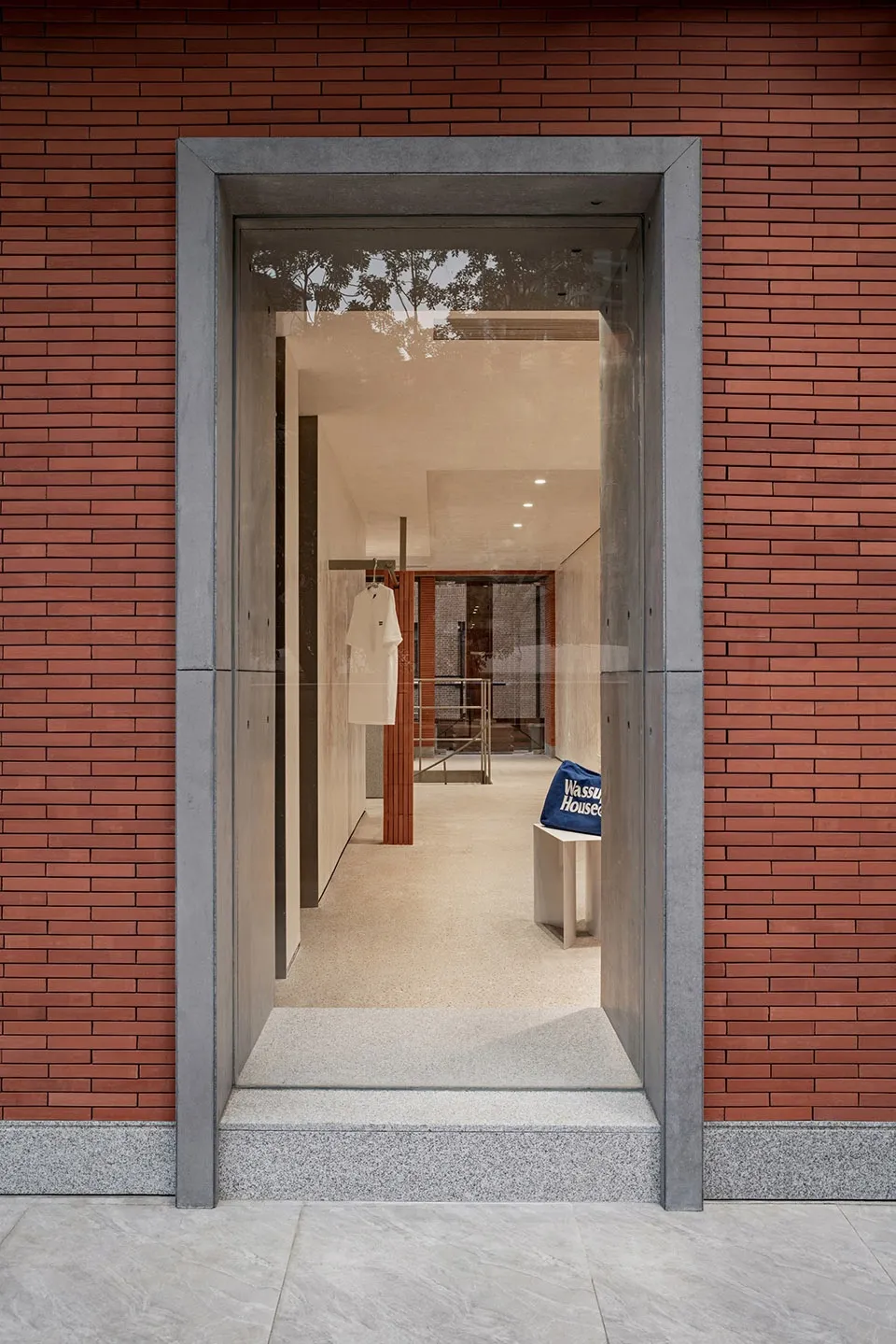 Exterior view of a modern retail storefront featuring brick walls and large glass windows.