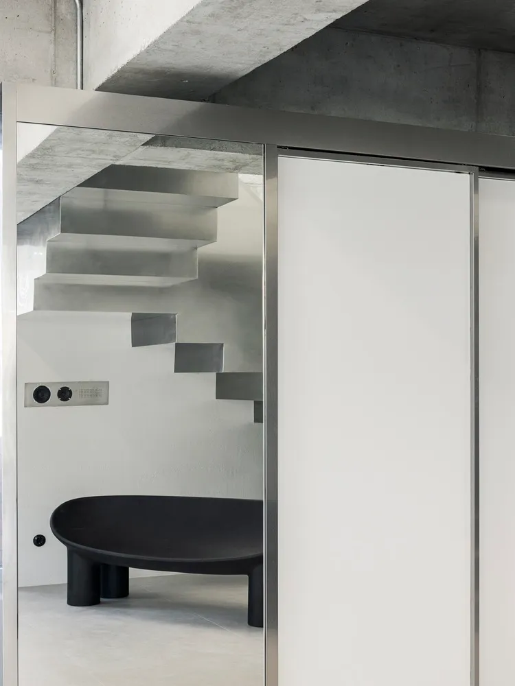 Modern interior with concrete stairs and steel furniture