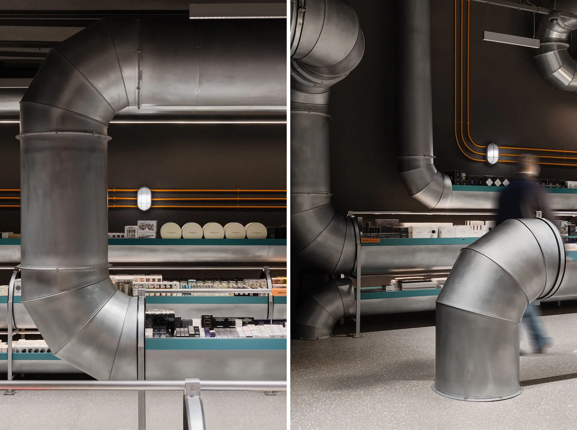 A retail storefront featuring large, metallic pipes against a dark, textured wall, creating an industrial aesthetic.