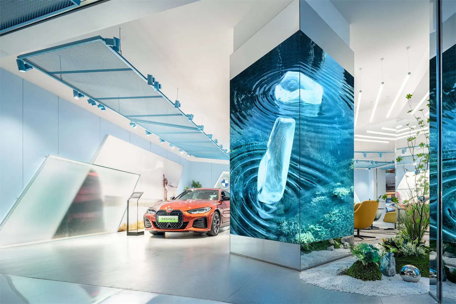 A minimalist car showroom with a glass wall and a red BMW car on display.