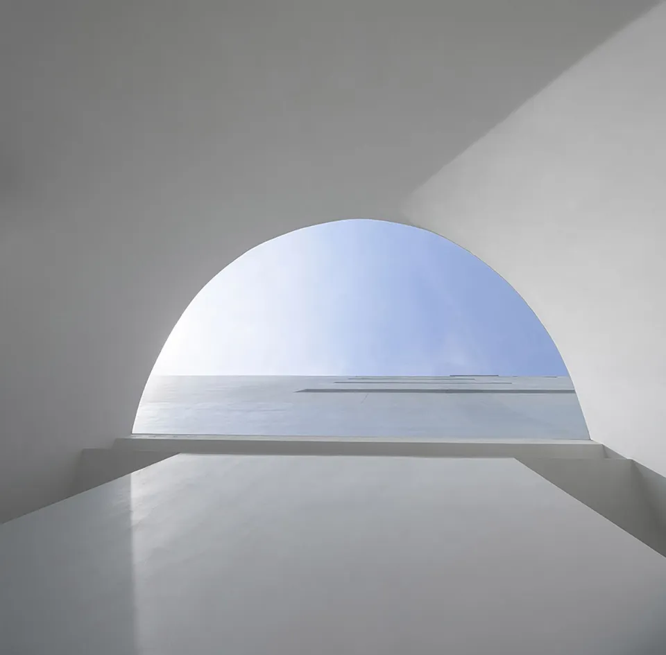 A minimalist white interior with concrete walls and floor.