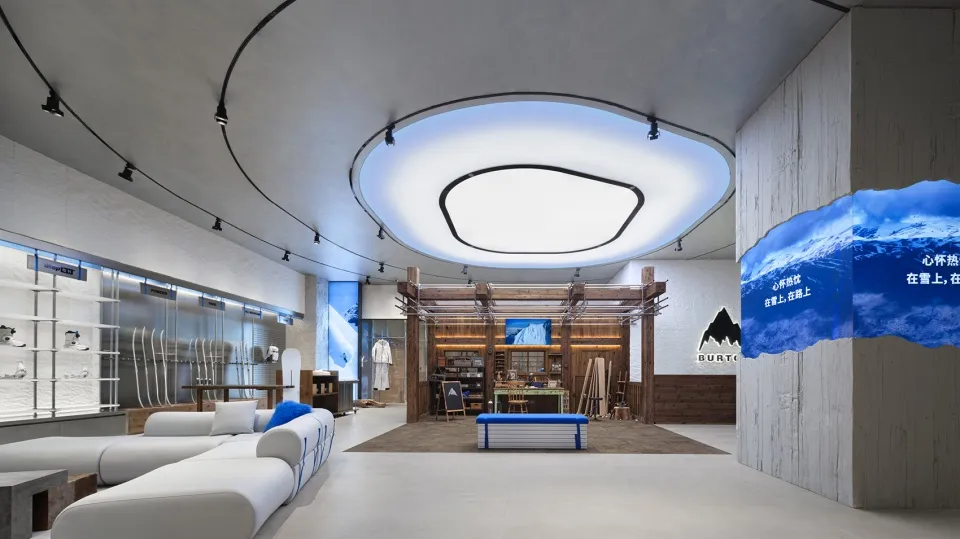 A modern, industrial-style retail ski shop with concrete walls and floors, glass showcases, and wooden accents.