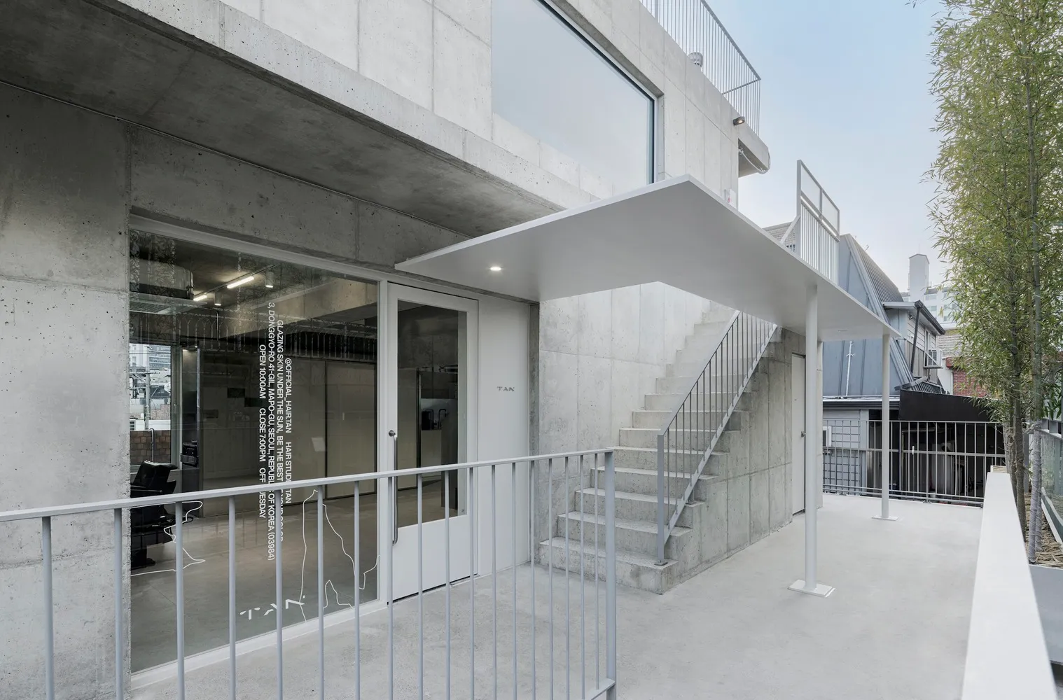 混凝土樓梯與大型窗戶及鋼製扶手的外部建築。