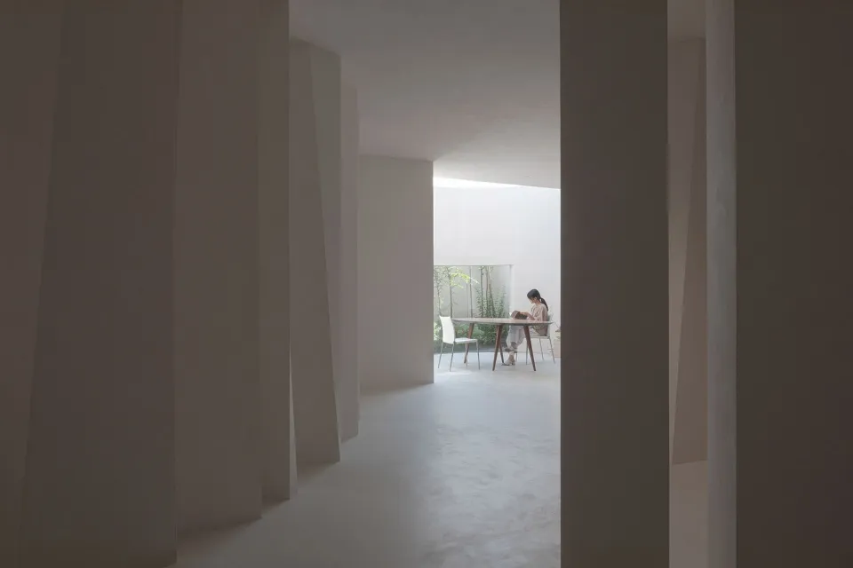 A minimalist living room with a concrete floor and white walls.