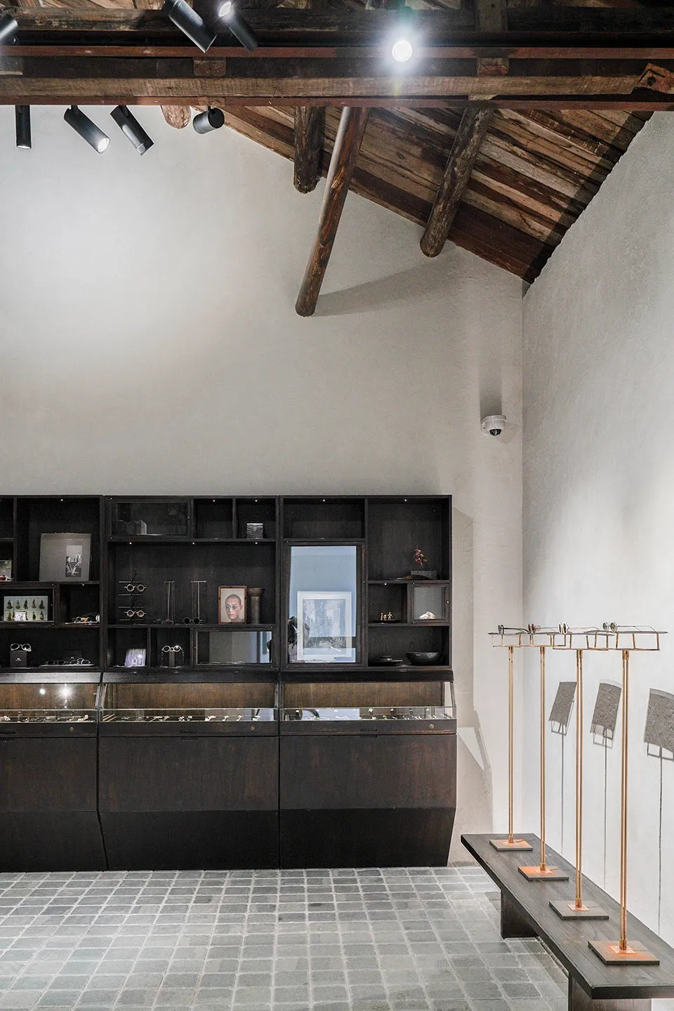 A modern retail display case with black wood shelves and glass doors, featuring sleek design elements.