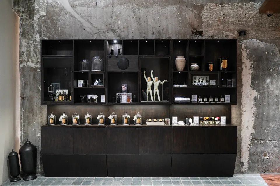 A retail storefront displaying glass, dark wood, and concrete accessories in an upscale, modern setting.