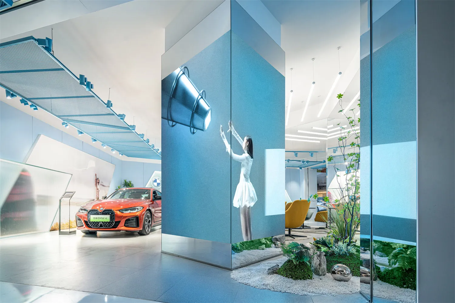 A car showroom featuring a modern interior design with blue lighting, metal accents, and green plants.