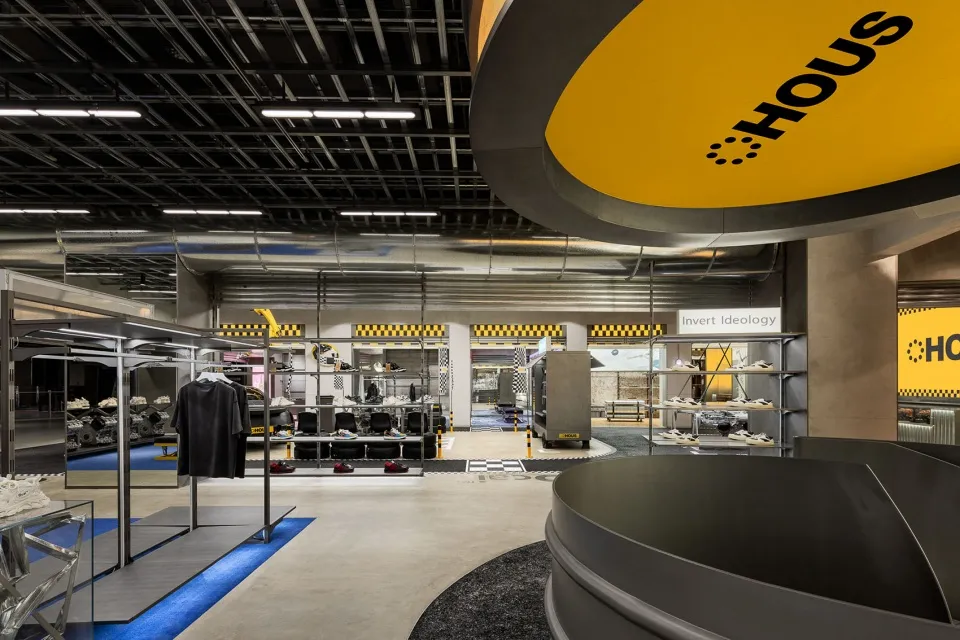 A modern fashion retail store with metallic finishes, concrete flooring, and glass displays.