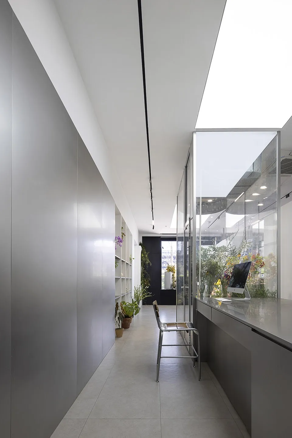 Modern office space featuring glass walls, metal accents, and concrete flooring.