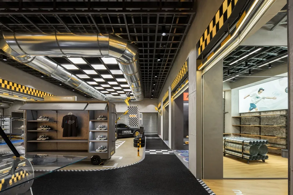 現代零售室內以金屬與混凝土元素打造,展示玻璃陳列櫃的鞋履店,帶有工業風格