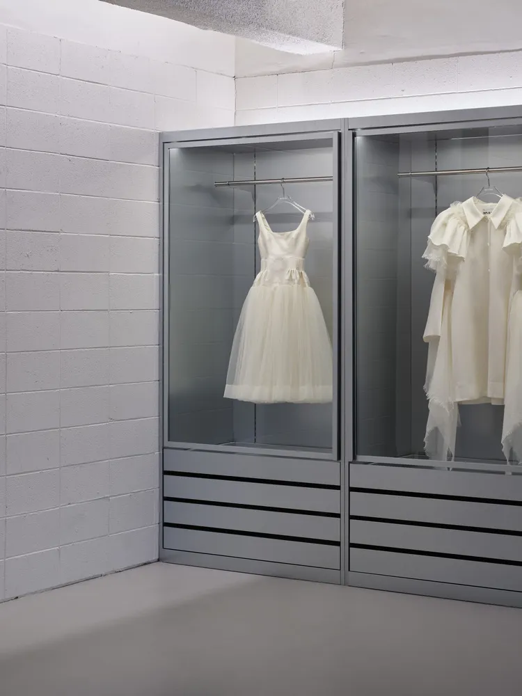 Modern, minimalist clothing display cabinets made of glass.