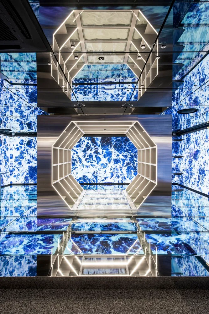 Modern shopping center exhibit featuring metallic frames and a dramatic blue marble backdrop.